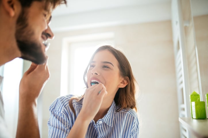 Shot of a young couple brushing their teeth