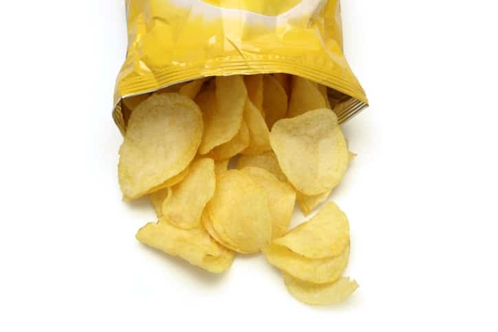 Bag of golden chips isolated on a white background.